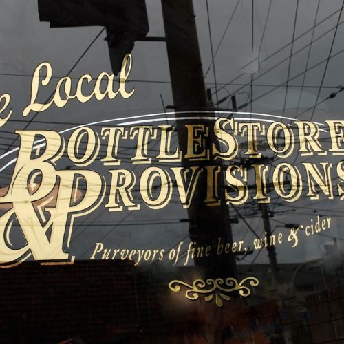 on glass gold leaf gilded window signwriting the local bottlestore and provisions